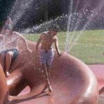 Un bambino si bagna per combattere il caldo