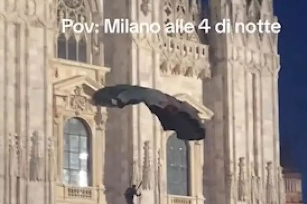 Il base jumper che si lancia dalle guglie del Duomo di Milano con il paracadute con i colori della Palestina