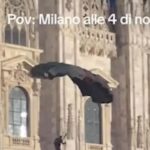 Il base jumper che si lancia dalle guglie del Duomo di Milano con il paracadute con i colori della Palestina