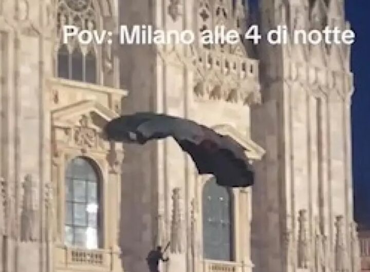 Il base jumper che si lancia dalle guglie del Duomo di Milano con il paracadute con i colori della Palestina