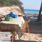 Allestiscono tavolata nella riserva naturale: sedie, tavoli e borse con il cibo sulle dune del Salento