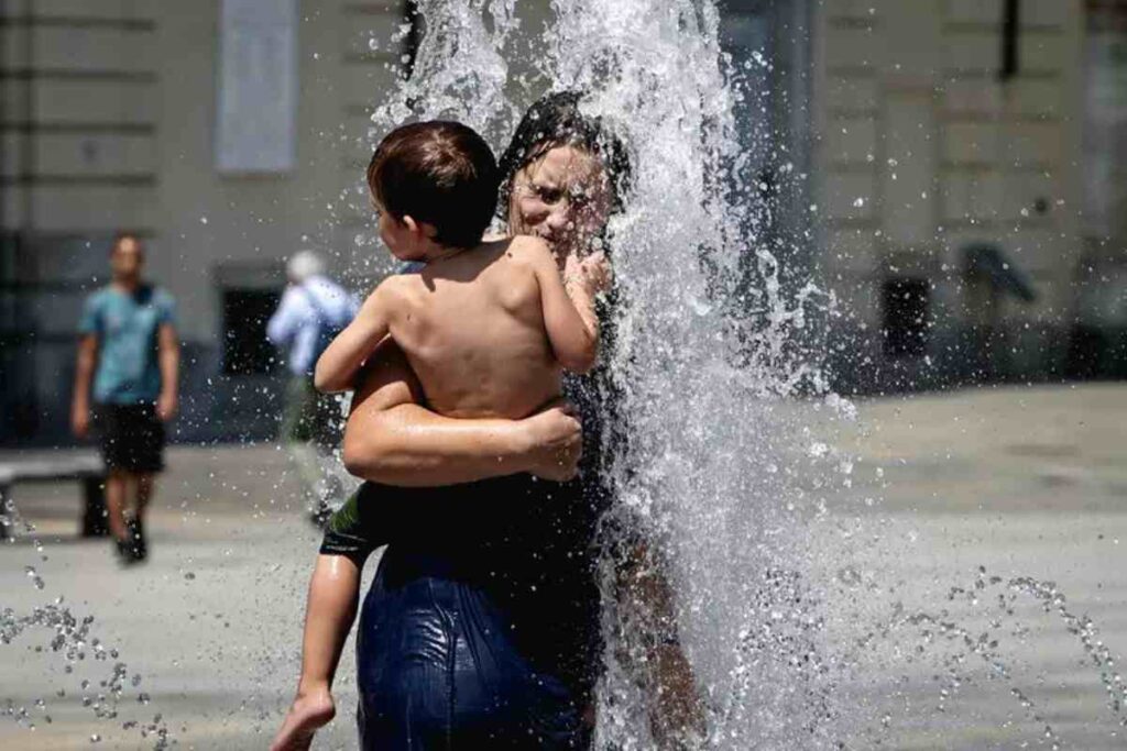 Donna si rinfresca sotto l'acqua