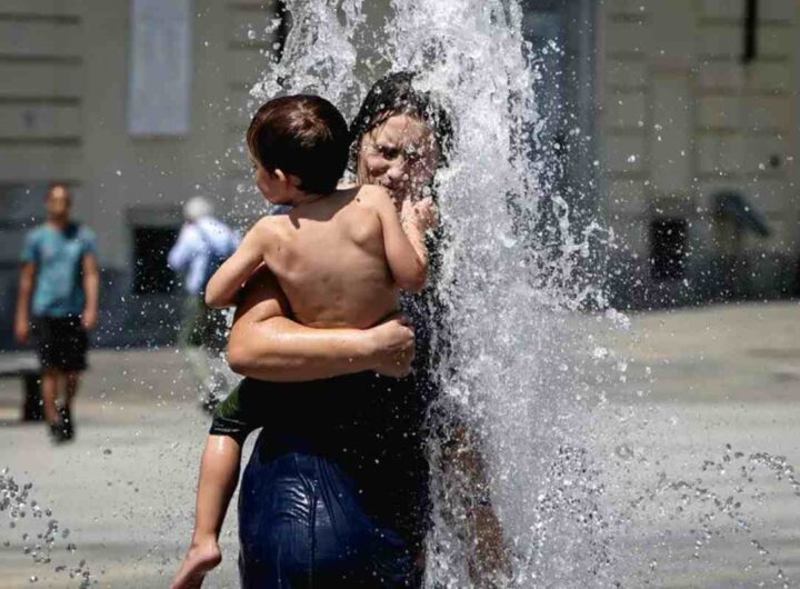 Donna si rinfresca sotto l'acqua