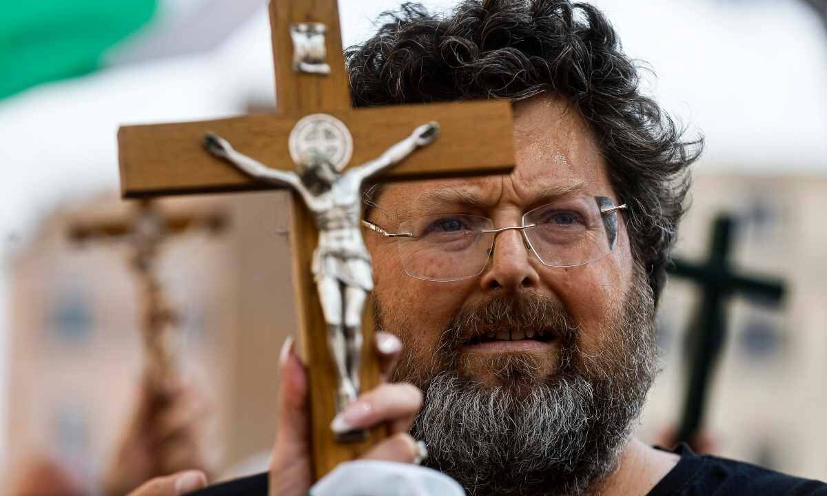 Mario Adinolfi con il crocifisso in mano