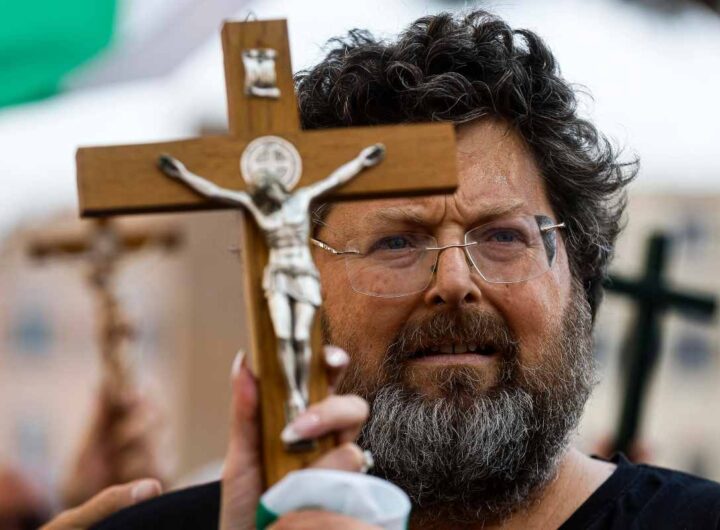 Mario Adinolfi con il crocifisso in mano