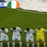 I giocatori dell'Irlanda con il lutto al braccio chinano la testa durante l'inno di Israele