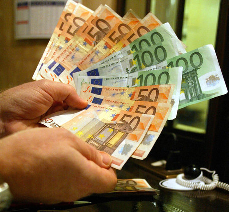 Un uomo tiene in mano alcune banconote di Euro
