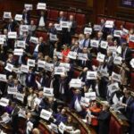 L'opposizione in Aula con i cartelli "legge truffa"