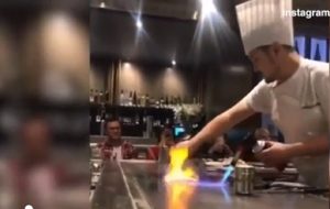 chef giapponese cucina con la fiamma sulla piastra
