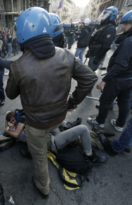 Corteo dei movimenti, un agente sale sui manifestanti abbracciati