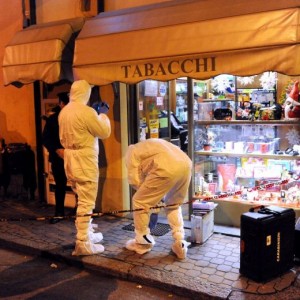 La Polizia scientifica all'esterno di una tabaccheria ad Asti, dove il titolare, Manuel Bacco, è stato ucciso durante una rapina dopo una sparatoria (foto Ansa)