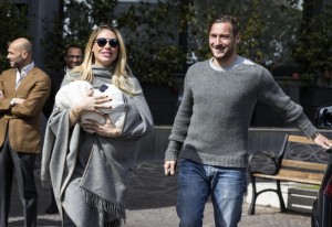 Ilary Blasi e Francesco Totti con Isabel lasciano la clinica (foto Ansa)
